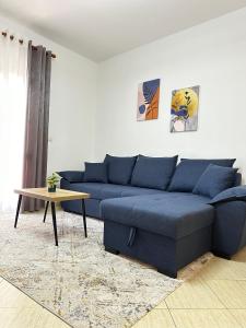 a living room with a blue couch and a table at Odi Apartments in Durrës