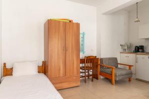 a bedroom with a bed and a cabinet and a kitchen at Sifnos studio 7 in Sifnos