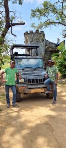 deux hommes se tiennent devant un camion dans l'établissement Humbhaha jungle nature eco resort, à Kataragama