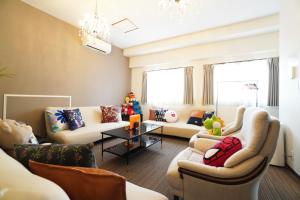 uma sala de estar com sofás e um lustre em Sakurajima Parkside House A em Osaka