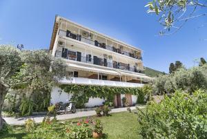 een groot wit gebouw met balkons en een tuin bij Tasoula Studio with garden view in Nikiana
