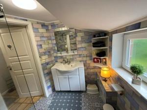 a bathroom with a sink and a mirror at Ferienhus Aline in Krummhörn