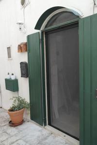 a green door with a plant next to a building at Foglia d'Ulivo in Ostuni
