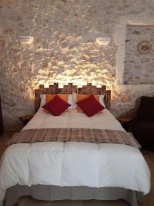 a bedroom with a white bed with red pillows at Foglia d'Ulivo in Ostuni