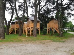 two cottages in the woods with trees at Camping Onlycamp du Moulin in Clisson