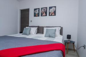 - une chambre avec un grand lit et une couverture rouge dans l'établissement Apartment Tina II, à Poreč