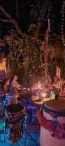 eine Gruppe von Menschen, die in einem Zimmer mit Kerzen sitzen in der Unterkunft Jungle river humbhaha hostel in Kataragama