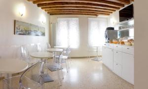 a kitchen with tables and chairs in a room at Hotel Adriatico in Venice