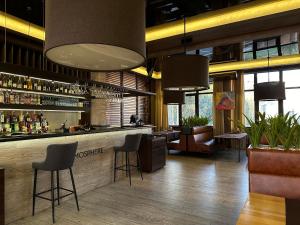 a lobby with a bar with chairs and tables at Hotel Atmosphere in Poltava