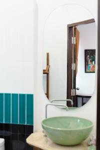 uma casa de banho com um lavatório verde e um espelho em Huen Hug Chiang Mai em Chiang Mai
