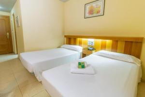 2 camas en una habitación de hotel con una toalla en la cama en Pacoche Murcia en Murcia