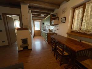 eine Küche mit einem Holztisch und Holzböden in der Unterkunft Agriturismo Maso Fumas in Canale dʼAgordo