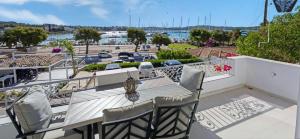 Porto Heli Seafront - Port House G في بورتوخيلي: شرفة مع طاولة وكراسي وإطلالة على ميناء