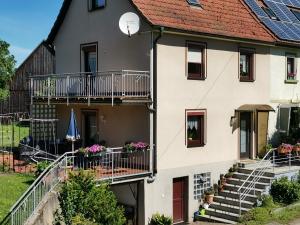 una casa con balconi e scale di fronte di FeWo Ulbrich Langenstadt a Neudrossenfeld
