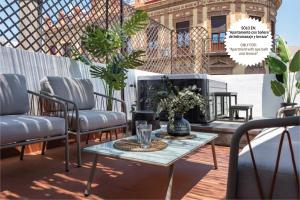 d'une terrasse avec des chaises et une table sur un balcon. dans l'établissement Suites Maestranza - Puerta del Arenal by Magno Apartments, à Séville