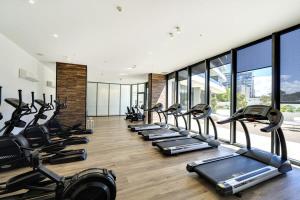 een fitnessruimte met een stel loopbanden in een kamer bij Modern 1-Bed Apartment With Parking, Pool and Gym in Phillip