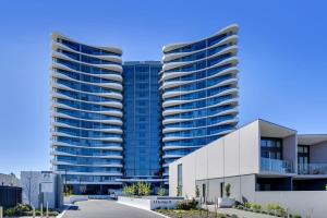 un gran edificio de apartamentos con dos torres altas en Modern 1-Bed Apartment With Parking, Pool and Gym en Phillip