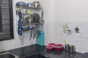a kitchen counter with pots and pans on a wall at Shree Bankebihari Niwas in Vrindāvan