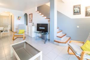 a living room with a couch and a tv at Grifeu 151 - Casa adosada con piscina comunitaria in Llança
