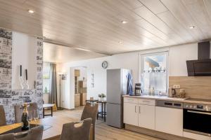 a kitchen with white cabinets and a table with chairs at Ferienhaus Bornwiese in Schwalmtal
