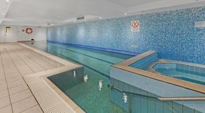 a large swimming pool in a large room at Central 1-Bed with Parking, Pool, Sauna & Gym in Sydney