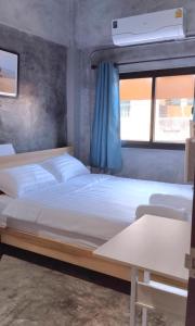 1 dormitorio con 2 camas y ventana en Captain Joe Cafe & Hostel, en Hua Hin