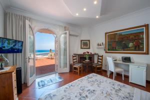 a bedroom with a table and a dining room with a view of the ocean at Villa Briganti Seaview Terrace in Positano