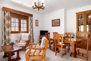 a dining room with a wooden table and chairs at Casa Buganvilla in Conil de la Frontera
