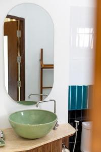 a bathroom with a green bowl on a counter with a mirror at Huen Hug Chiang Mai in Chiang Mai