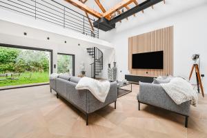 Una sala de estar con dos sofás y un televisor. en L'Arty - Maison avec jardin - 6p, en Villemomble