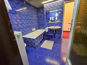 niebieska łazienka z wanną i umywalką w obiekcie Hotel Sporn w mieście Radomlje
