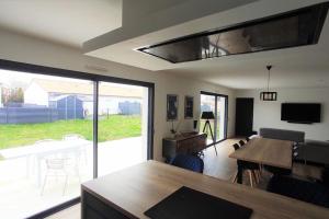 a living room with a table and a dining room at Le Refuge des Artistes in Vezins
