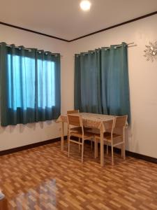 - une table et des chaises dans une chambre dotée de rideaux bleus dans l'établissement FN'C GUEST HOUSE, à San Juan