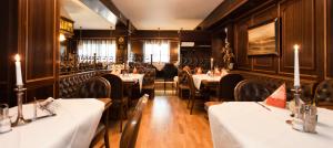 ヒュルトにあるHotel-Restaurant Breitenbacher Hofの白いテーブルとキャンドルが置かれたテーブルと椅子のあるレストラン +30枚の写真