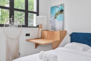 Un dormitorio con un escritorio al lado de una cama. en L'Arty - Maison avec jardin - 6p, en Villemomble