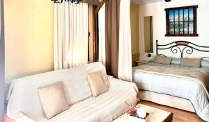 sala de estar con 2 camas y sofá en Hotel Hospederia Zacatin en Alcalá la Real