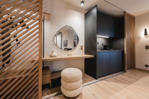 a bathroom with a vanity with a mirror and a stool at Revi Mountain Resort in Kalavrita