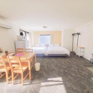 Un dormitorio con dos camas y una mesa y un escritorio. en 龙猫民宿-梅田店503, en Osaka