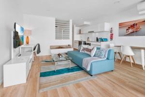 sala de estar con sofá azul y mesa en Spacious 2-Bed Unit With Balcony Next to The Gabba en Brisbane