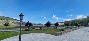 a park with a street light and trees and a river at El Mirador de Covas - 2 Hab - Garaje in Covas