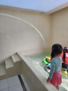a little girl is playing in a swimming pool at Hound Hotel Gijang Osiria in Busan