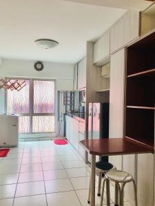 een keuken met een tafel en twee krukken. bij Duplex Axis Condo @Ampang nearby KLCC. in Ampang