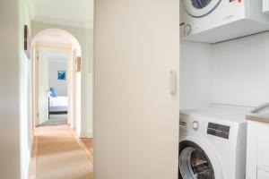 lavadero con lavadora y secadora en Historic Boutique Apartment Steps From Everything, en Sídney