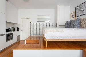 a bedroom with a large bed and a kitchen at Historic Art-filled Studio Close to Transport in Sydney