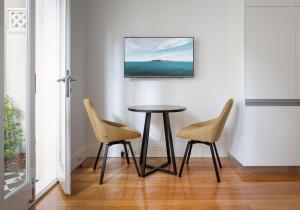 a dining room with a table and two chairs at Historic Art-filled Studio Close to Transport in Sydney