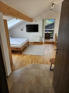 une chambre avec un lit et une télévision dans une pièce dans l'établissement alpinzeit.bayern Tanja und Thomas Preinfalk inkl. Chiemgaukarte, à Ruhpolding