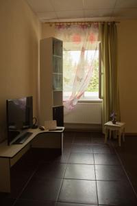 een kamer met een bureau, een computer en een raam bij VILLA ROZA Guest House in Rēzekne