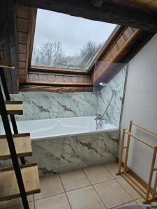a bathroom with a large window and a bath tub at Appartement Acolin in Briançon