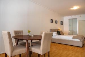 a bedroom with a bed and a table and chairs at Stylish Studio With Pool & Gym in Heart of Sydney in Sydney