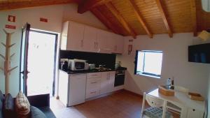 a kitchen with white cabinets and a table in a room at Chalet do Soajo in Arcos de Valdevez